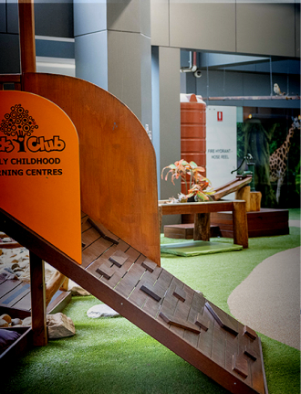 Column image Early childhood centre indoor playground with wooden climbing ramp and soft play area