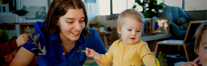 Column image Childcare educator playing with toddler during indoor learning activity