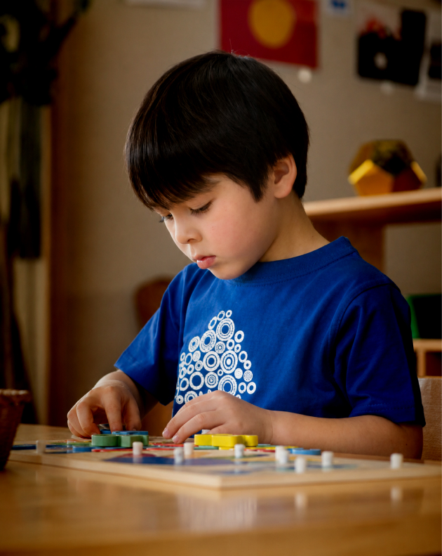 Column image Child participating in a Kids Club School Readiness Program learning activity using educational puzzles and fine motor skill development tools.