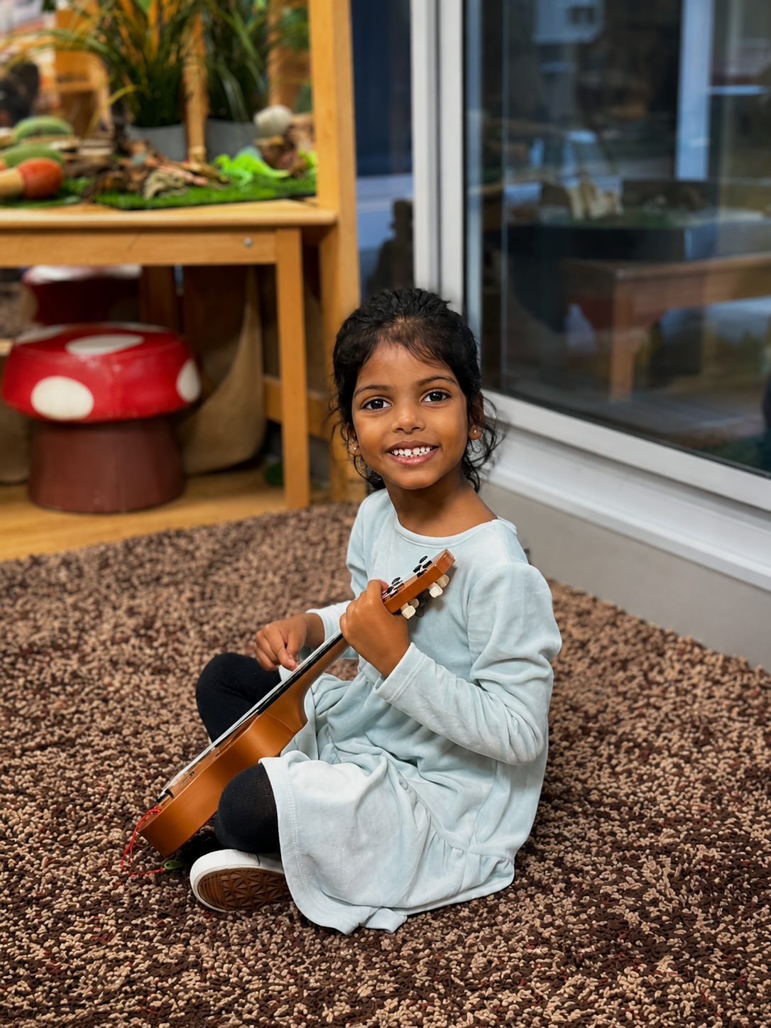Column image Kids Club child enjoys Ukelele practice